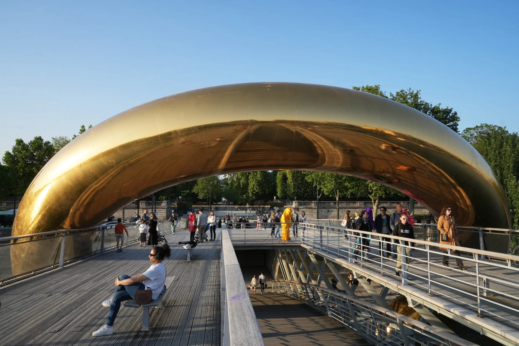 a giant inflatable sculpture of a gold ring encompassing a bridge